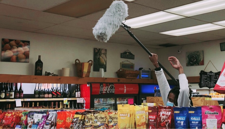 crew member holding a boom mic during a scene